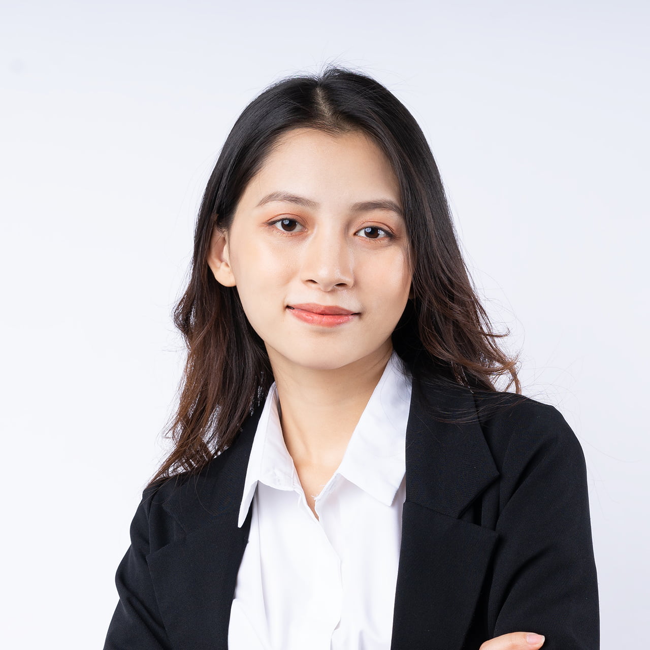 Portrait of young businesswoman wearing a suit, isolated on white background
